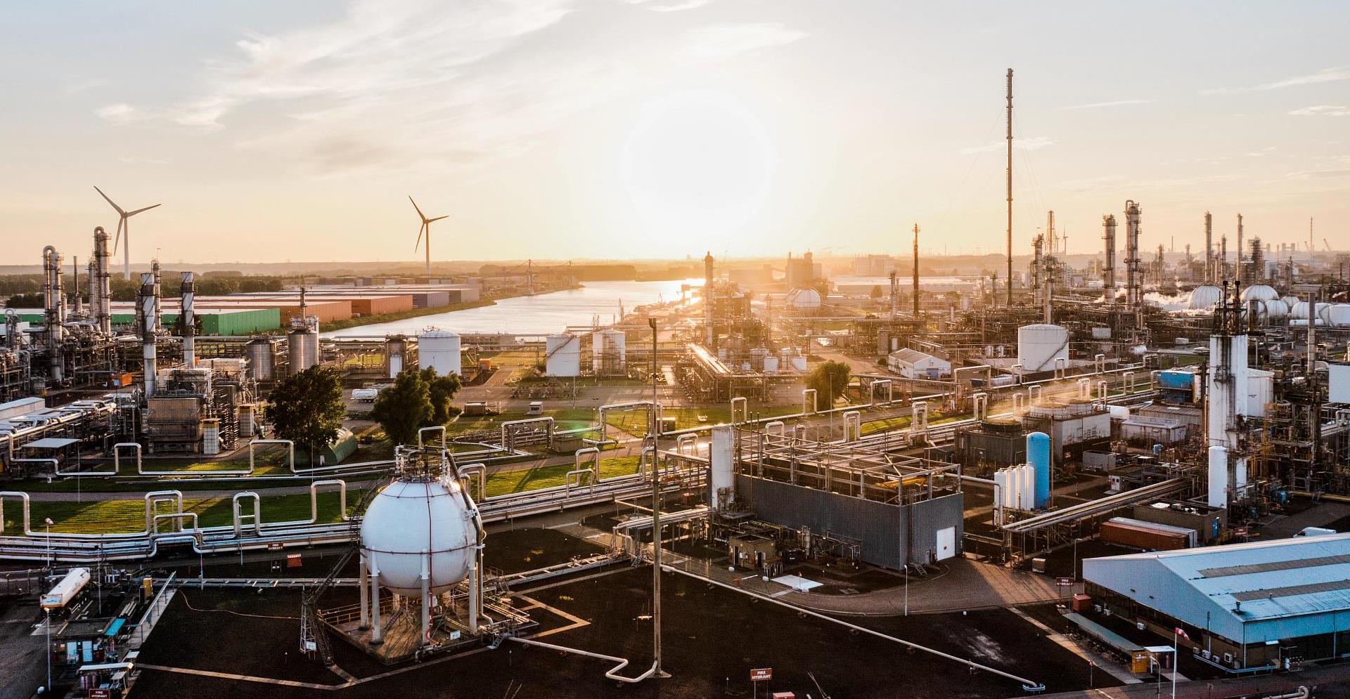 A surface level view of an industrial zone / power station at sunset - stock photo