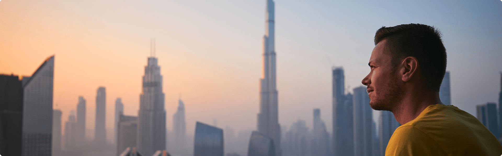 A man admires the breathtaking Dubai skyline, featuring towering skyscrapers and a vibrant urban landscape.