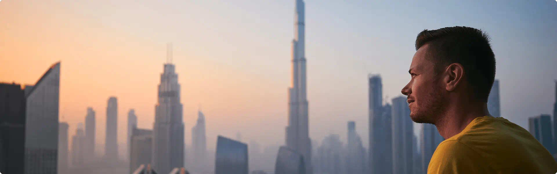 A man admires the breathtaking Dubai skyline, featuring towering skyscrapers and a vibrant urban landscape.