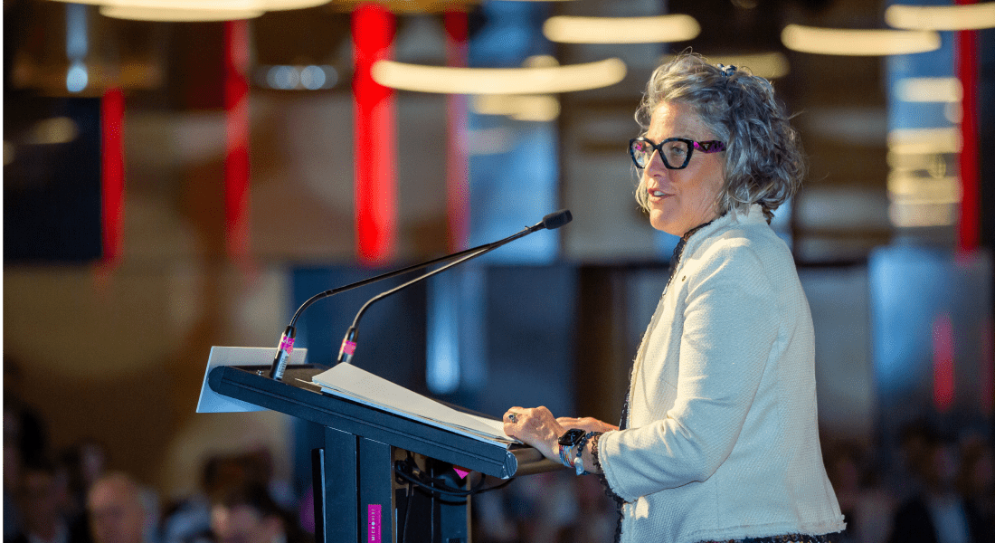 A woman addresses the audience at a conference, sharing insights and information during his speech.