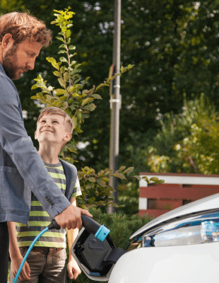Man en kind laden elektrisch voertuig op - Arcadis Nederland
