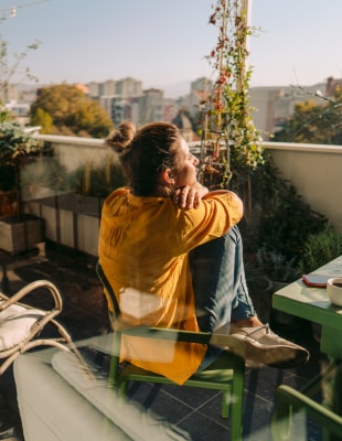 Vrouw geniet van uitzicht vanaf haar balkon. Natuur en biodiversiteit basis voor duurzame leefomgeving