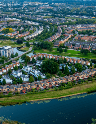Aerial view showcasing a residential area in the Netherlands, featuring houses, greenery, and organized streets.