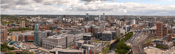 Aerial view of Manchester city center, showcasing its bustling streets, iconic buildings, and vibrant atmosphere.