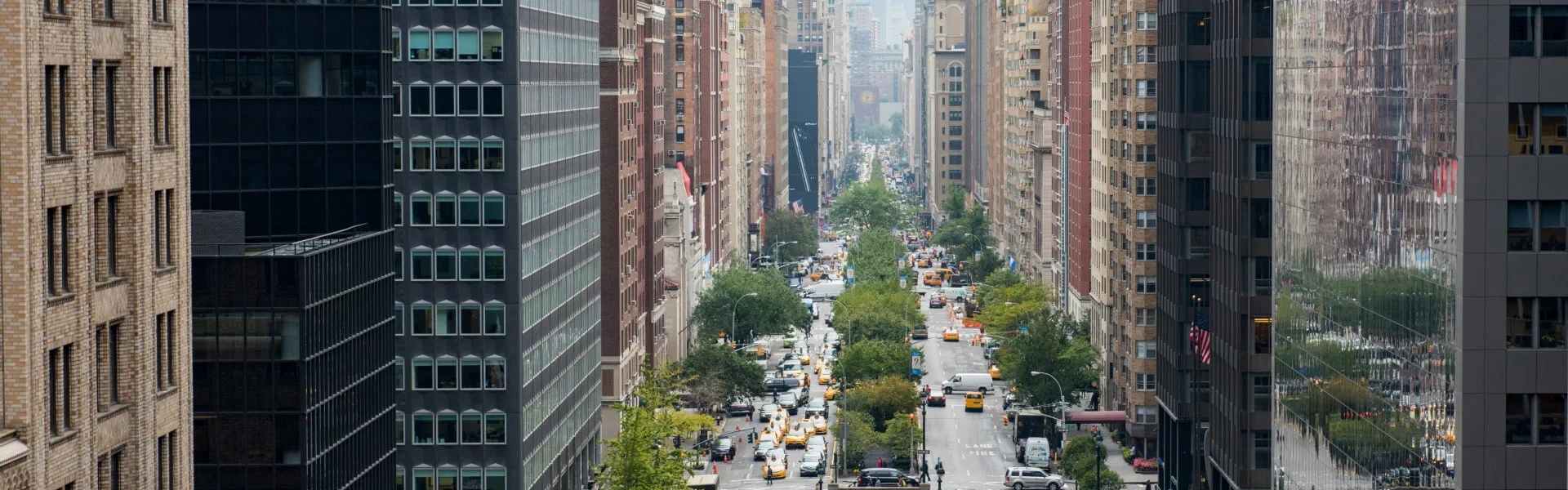  Aerial view of a bustling city street, showcasing buildings, vehicles, and pedestrians below.
