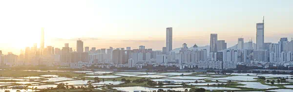 A city skyline featuring tall buildings reflected in the water below, showcasing urban architecture and natural elements.