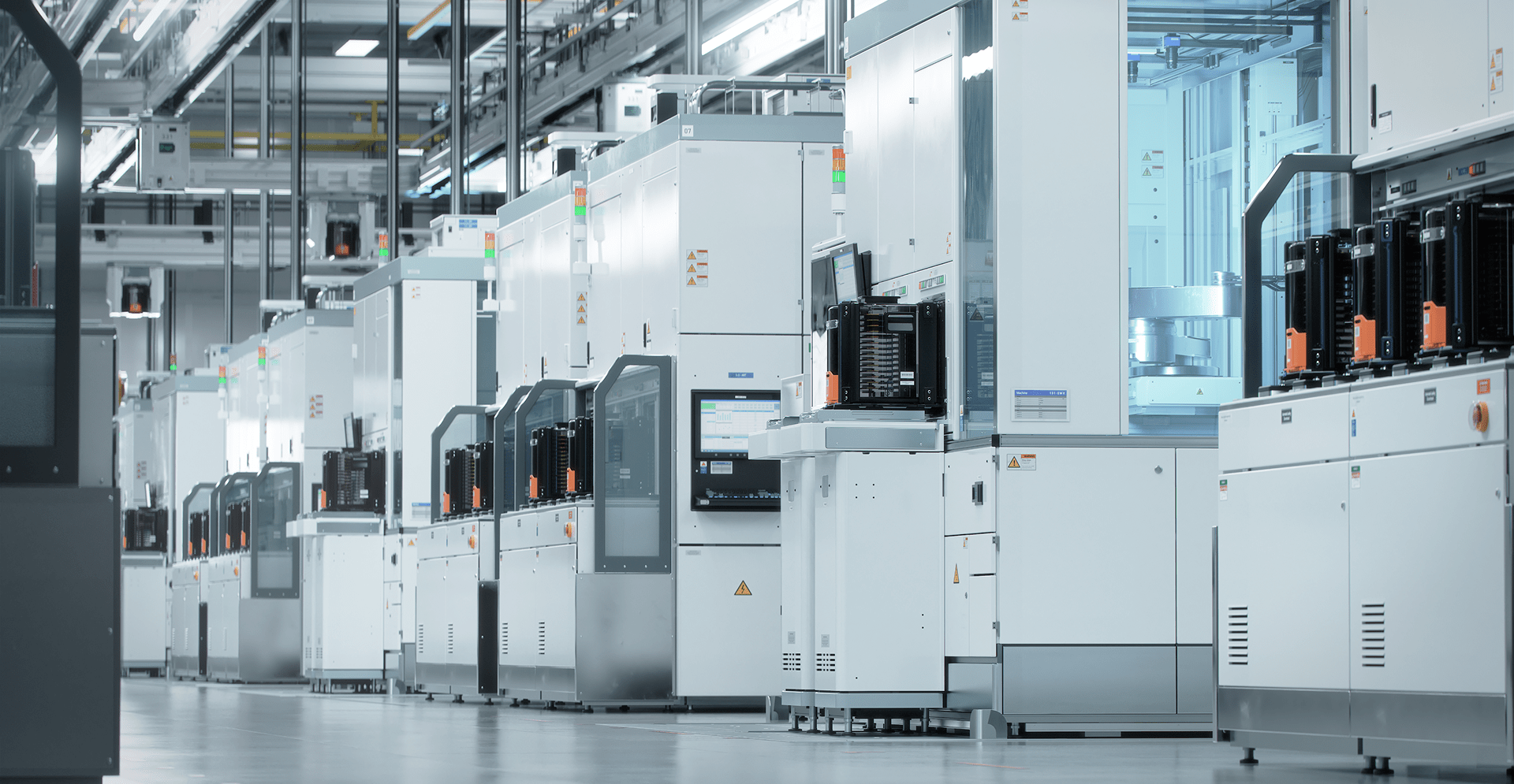 A row of industrial machines lined up in a factory setting, showcasing a workspace for manufacturing processes.