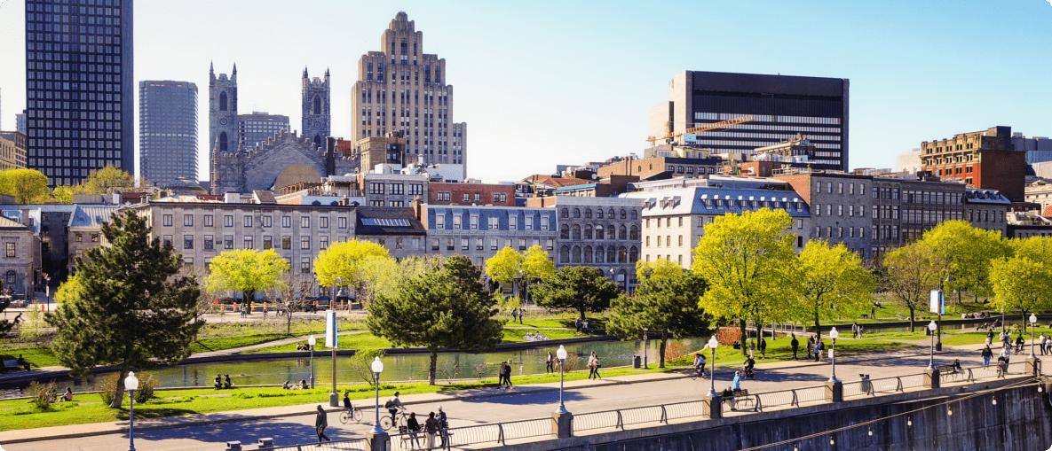 A city skyline with a river flowing in front and a bridge connecting both sides.
