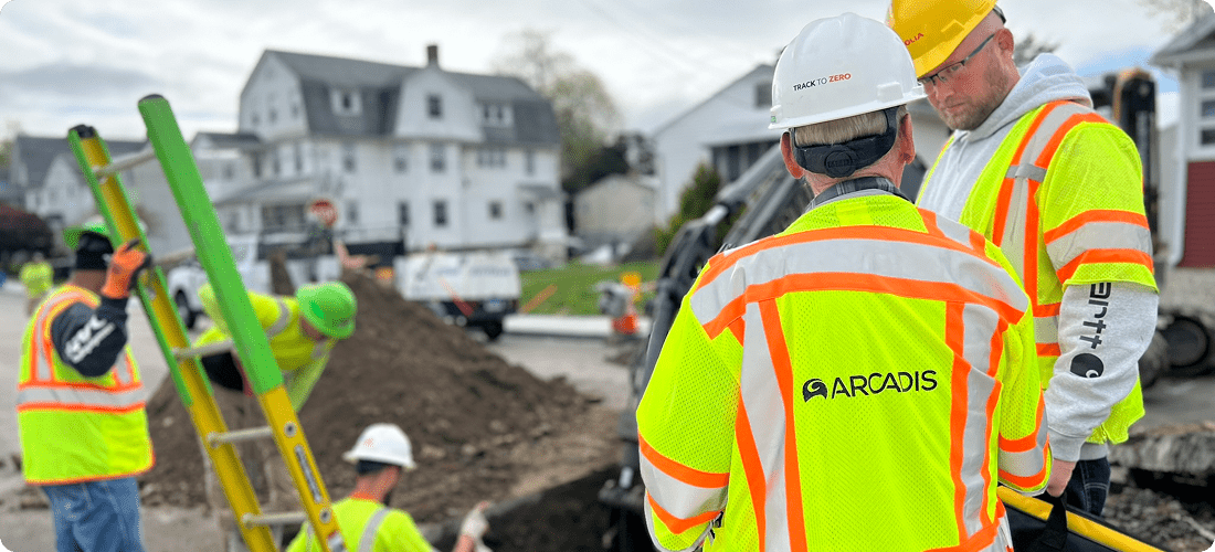 Group of men wearing safety vests and hard hats are working together on a construction site, ensuring safety and progress.