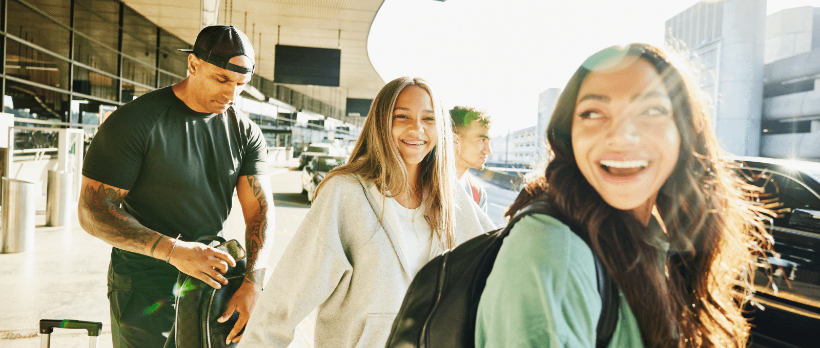 Four people with luggage walking through an airport terminal.