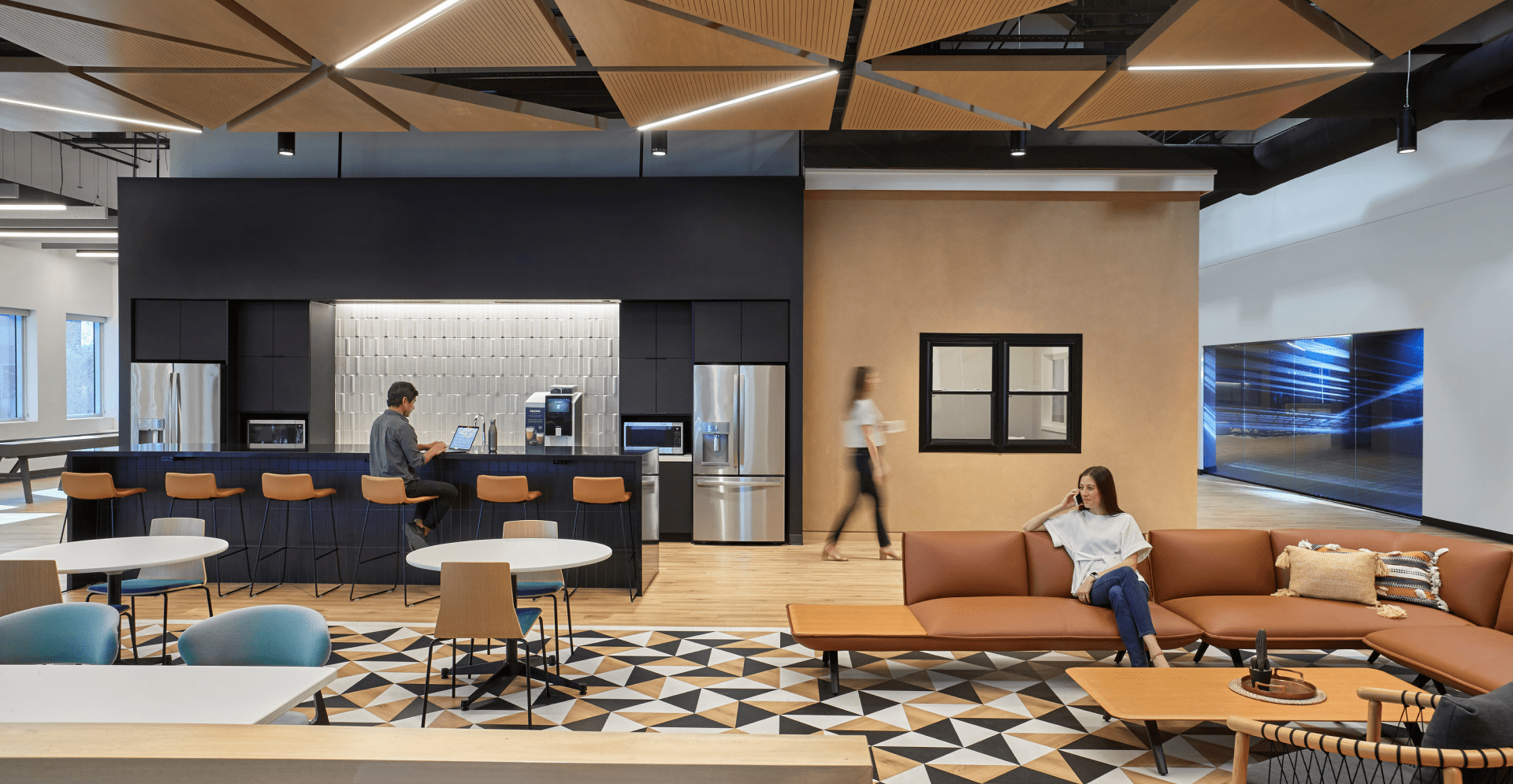 An expansive modern office space featuring an open design, characterized by sleek furnishings and a bright atmosphere.