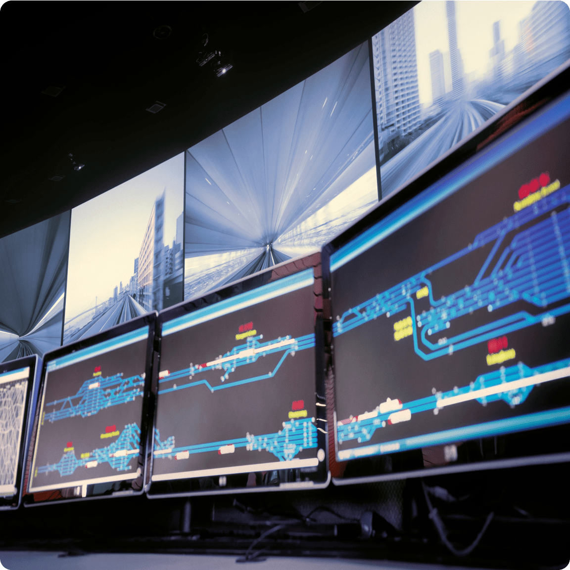 A workstation with several computer monitors, each presenting various images, illustrating a multi-tasking environment.