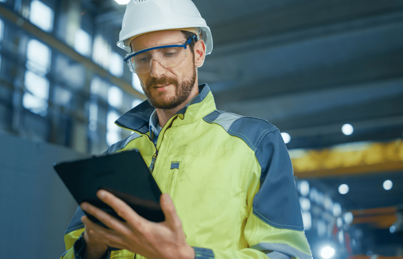 Image of a man with safety gear holding a tablet.
