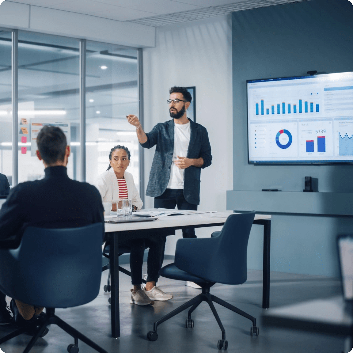 A man presenting to a group of people in a conference room.