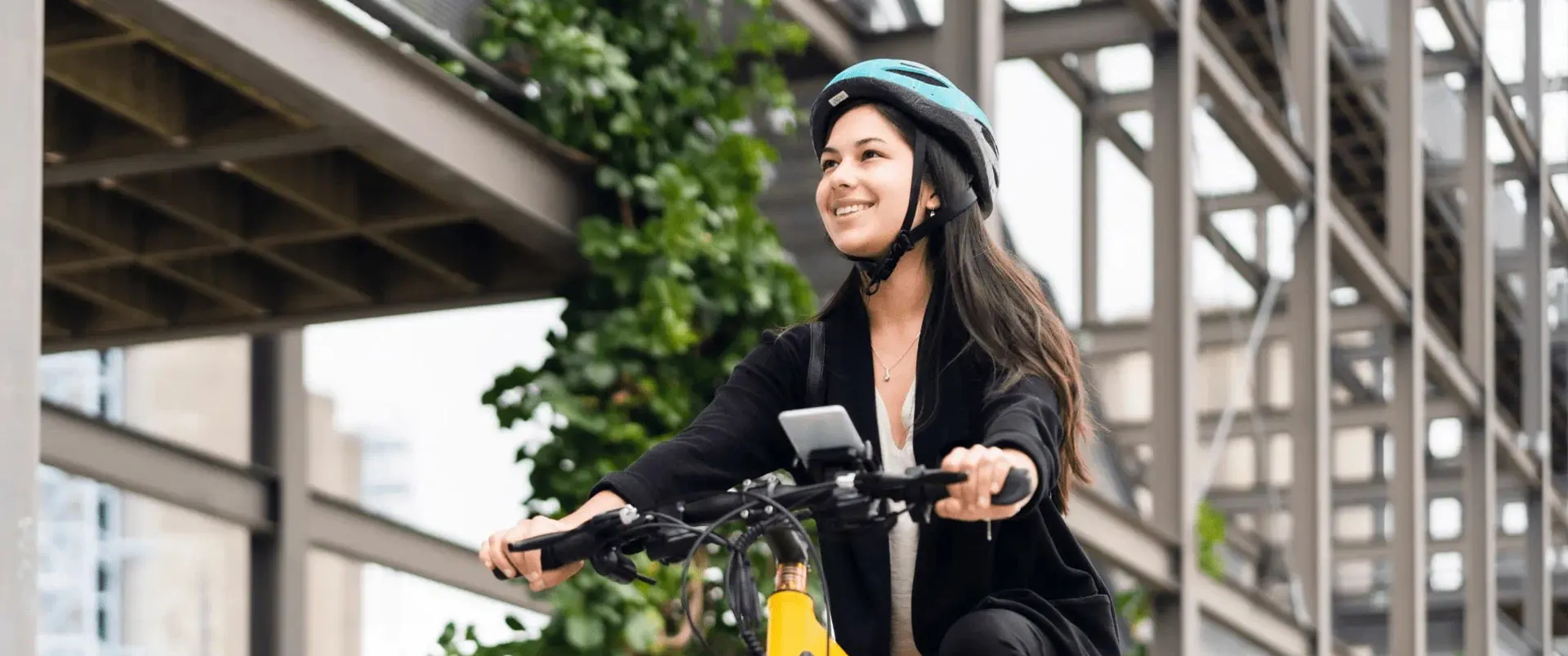 A woman wearing a helmet rides a bicycle, showcasing safety and enjoyment in outdoor cycling.