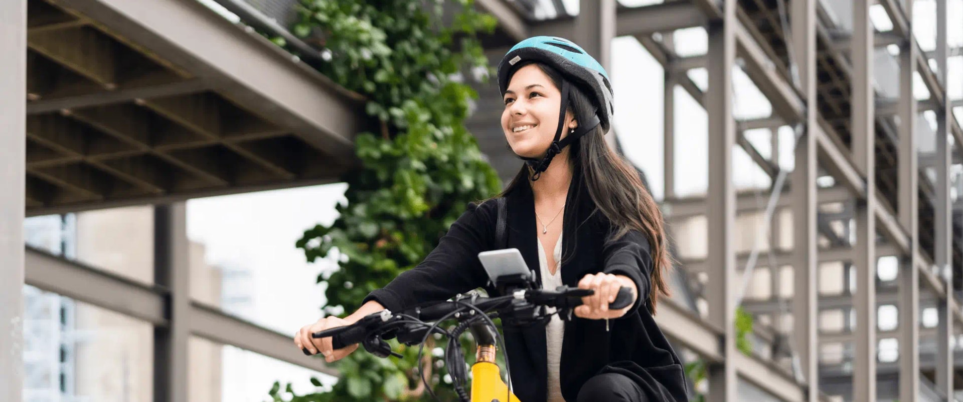 A woman wearing a helmet rides a bicycle, showcasing safety and enjoyment in outdoor cycling.