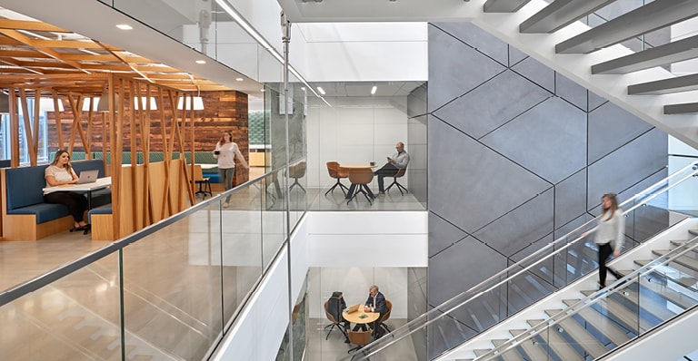 A modern office building atrium featuring glass walls and elegant stairs, showcasing a bright and open design.