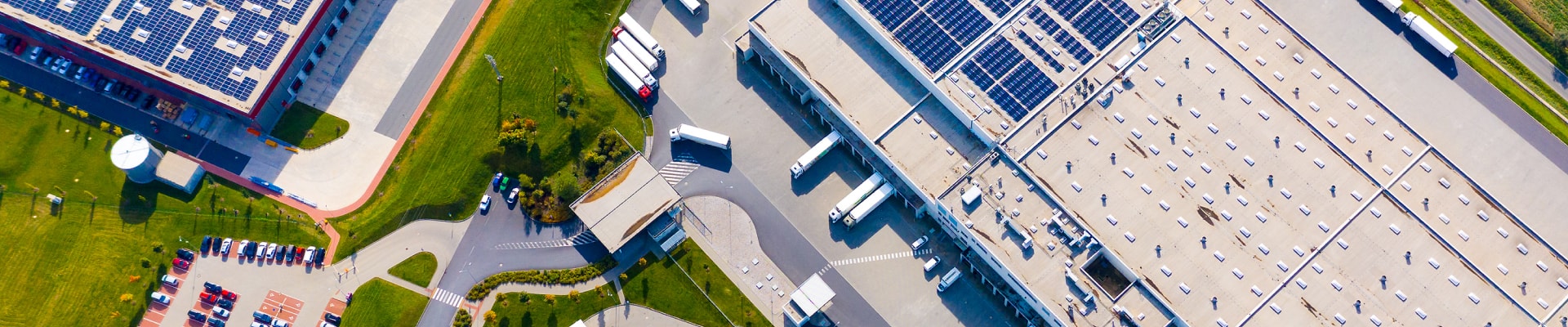 An aerial view of a large industrial building with solar panels, harnessing renewable energy for sustainable operations.