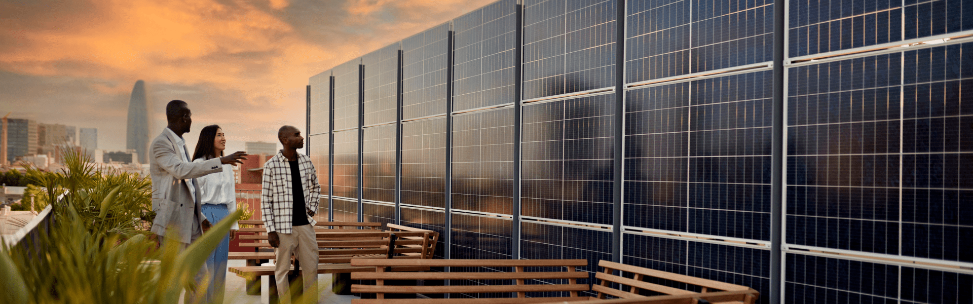 A diverse group of individuals standing on a rooftop, surrounded by solar panels, harnessing renewable energy.