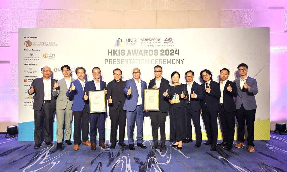 A diverse group of individuals displaying their awards while posing for a celebratory photo together.