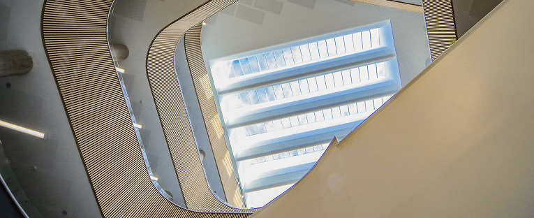  A stairway leading upward, featuring a large window positioned in the center, allowing natural light to illuminate the space.