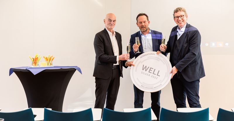 Proosten met champagne op zilveren Well Building Institute prijs voor Tapijn Universiteit Maastricht
