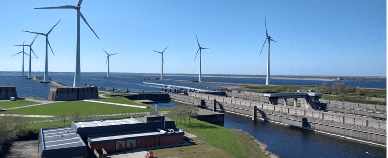 Wind turbines in water near canal, generating clean energy for sustainable future.