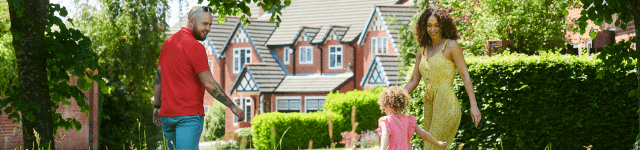 A family walking down a path with a house in the background.