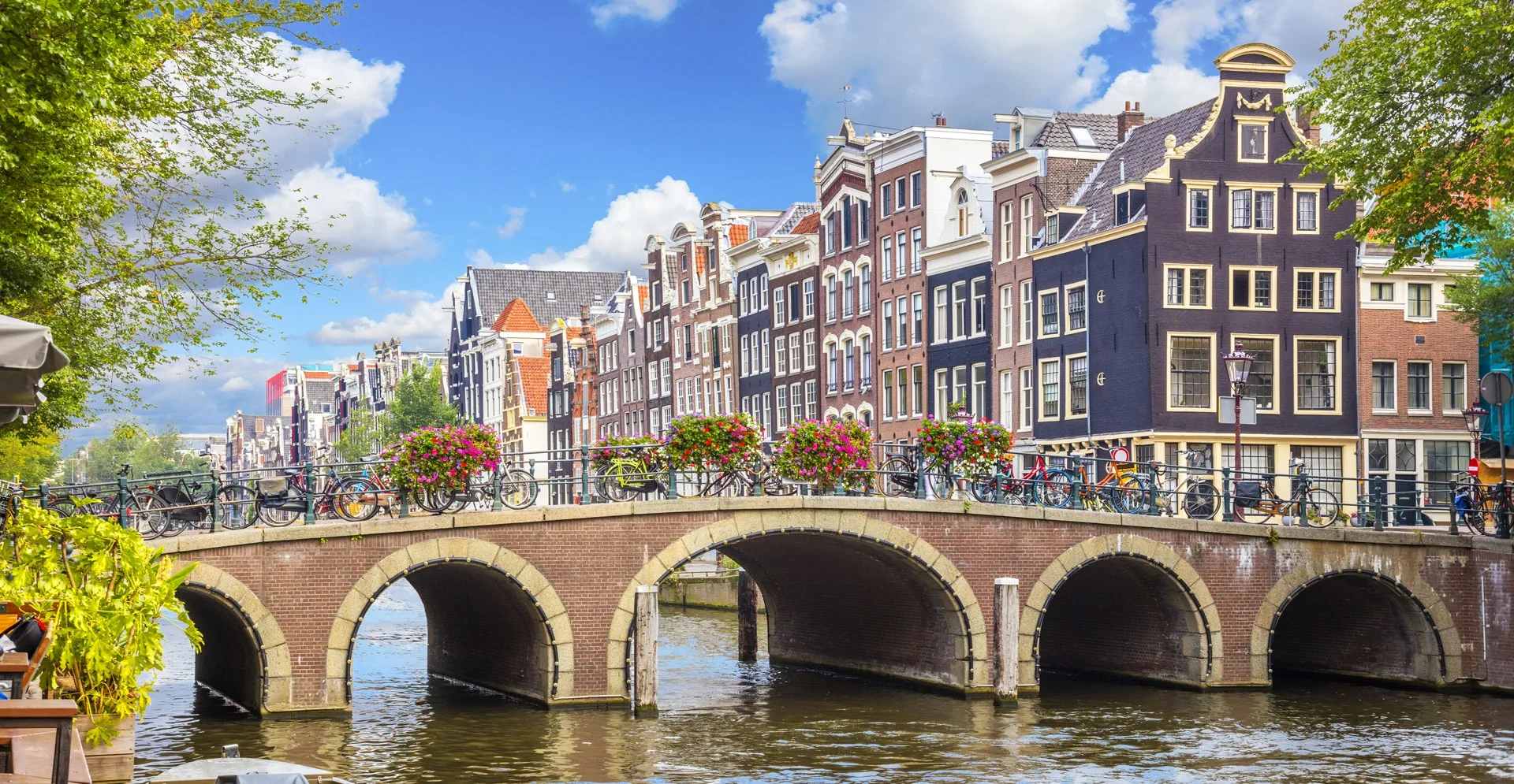 Amsterdam downtown - Amstel river, old houses and a bridge. Nice view of the famous city of Amsterdam. Travel to Europe.