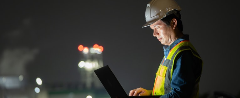 Asian programmer working on laptop at night