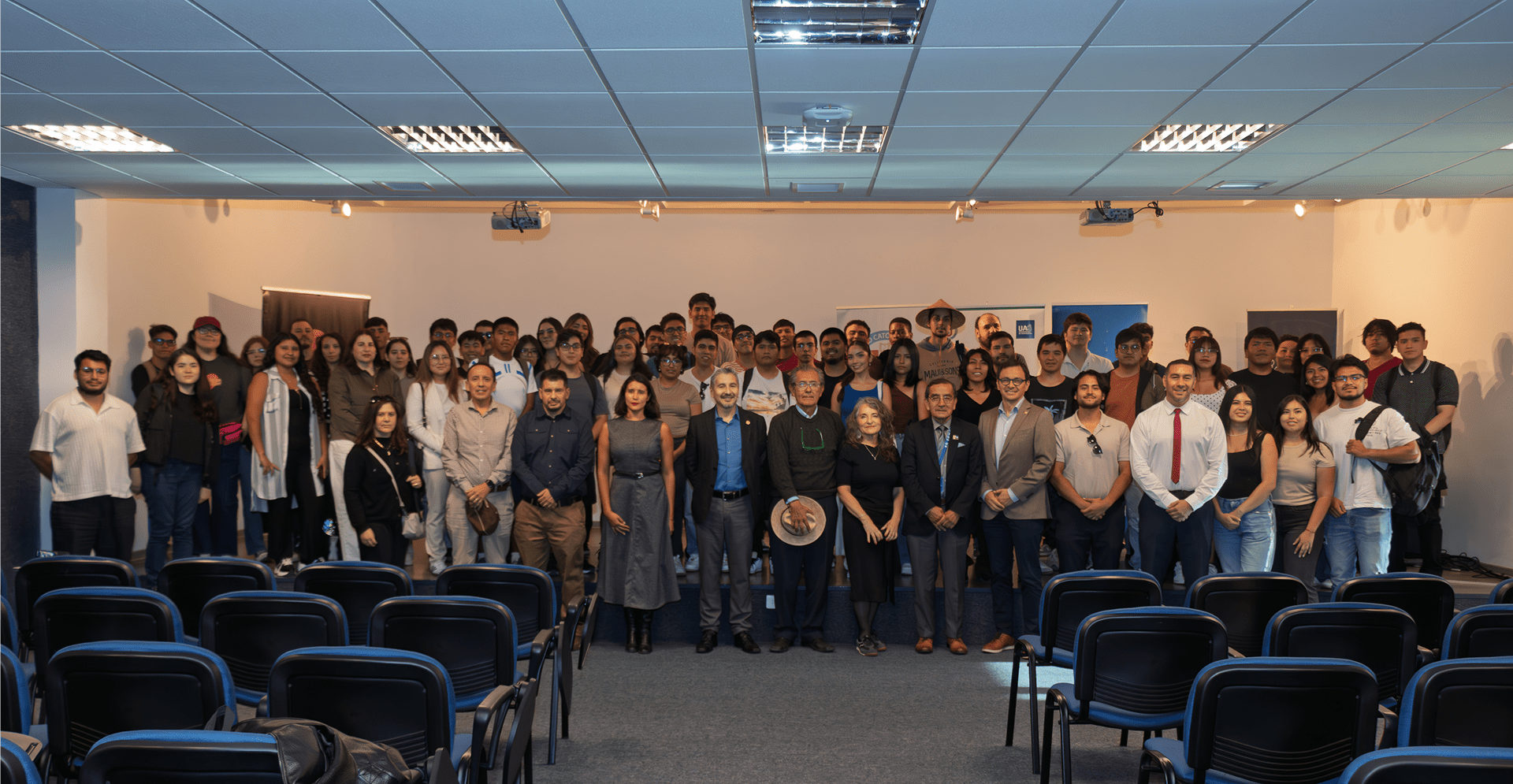 A diverse group of people standing together in a well-lit room, engaged in conversation.