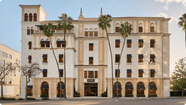 A hotel in a city with palm trees.