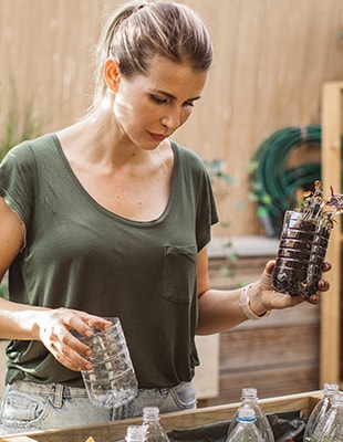 Vrouw die lege plastic fles hergebruikt als circulaire oplossingen voor minder CO2-uitstoot en zo een bijdrage levert aan een meer circulaire economie