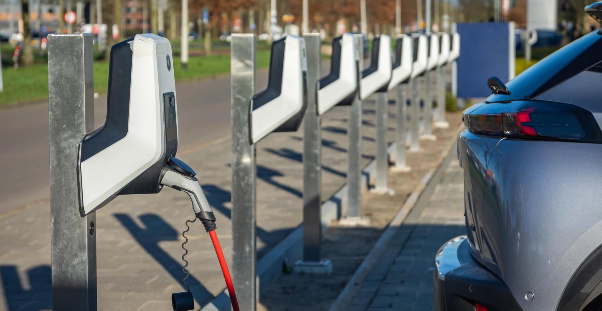 Elektrische auto opladen bij een oplaadpunt voor elektrische auto's om weer verder te kunnen met elektrisch rijden.