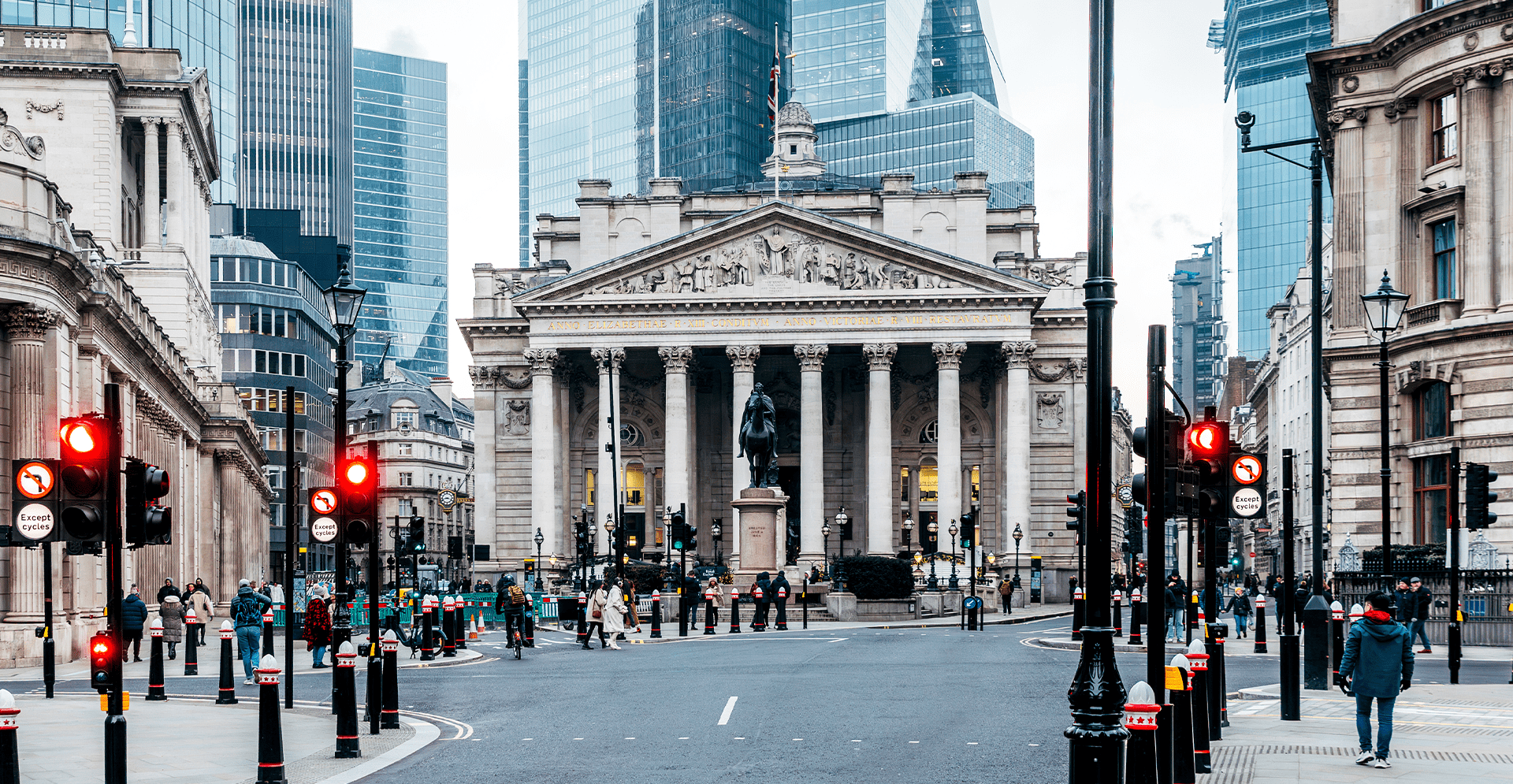 A busy street filled with pedestrians walking in front of a large building.