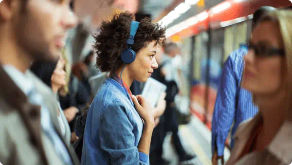 Woman listening to headphones in subway station