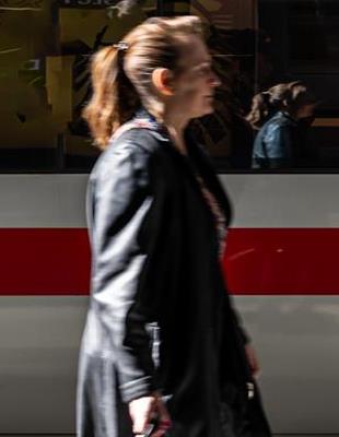 Blurred motion of woman walking in front of passenger train