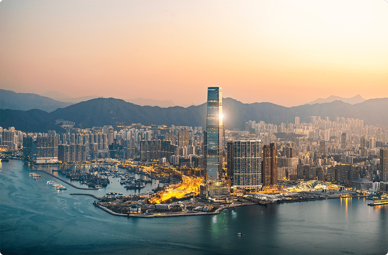 Hong Kong skyline illuminated by a vibrant sunset, showcasing skyscrapers against a colorful sky.