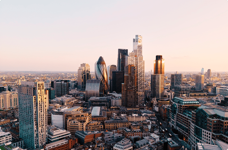 Aerial view of the London skyline, showcasing iconic buildings and structures against a clear blue sky.
