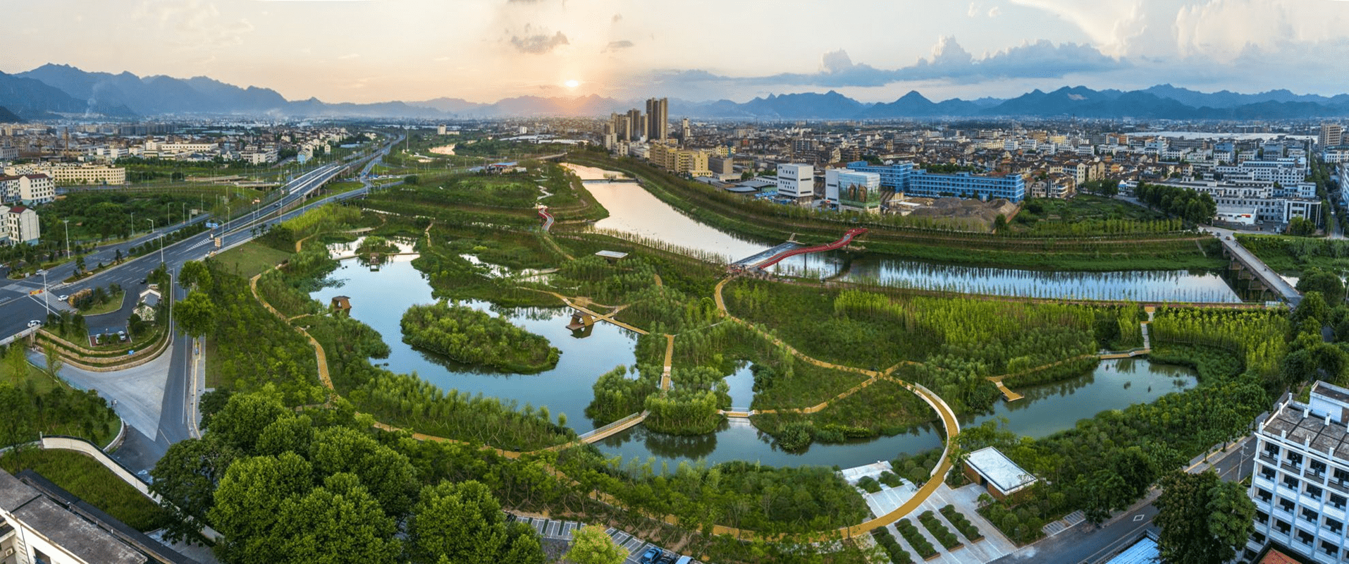 Scenic view of a city with a bridge over a river, set against a backdrop of urban architecture.