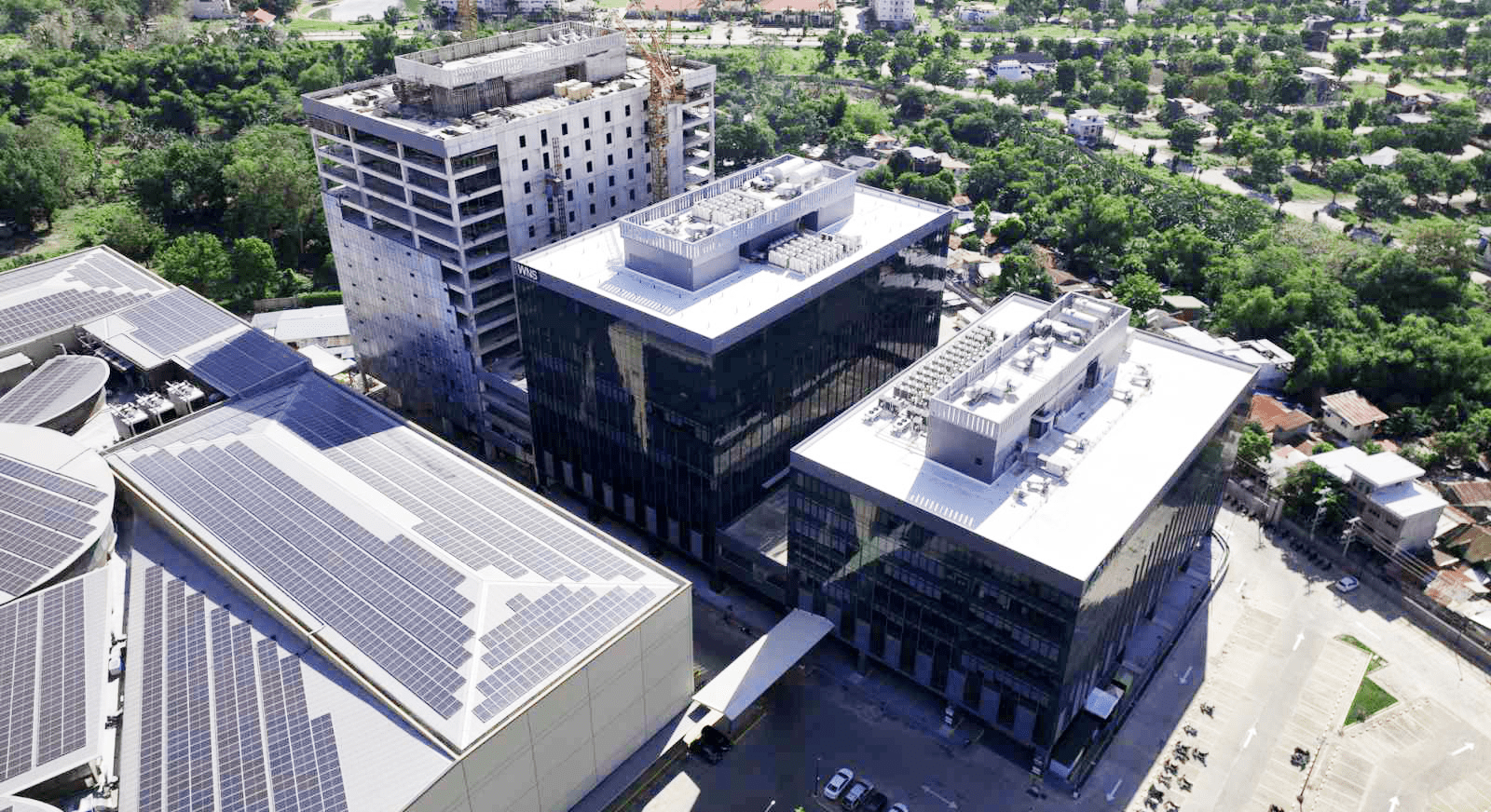 Aerial view of a large building featuring numerous solar panels on its roof, showcasing sustainable energy use.