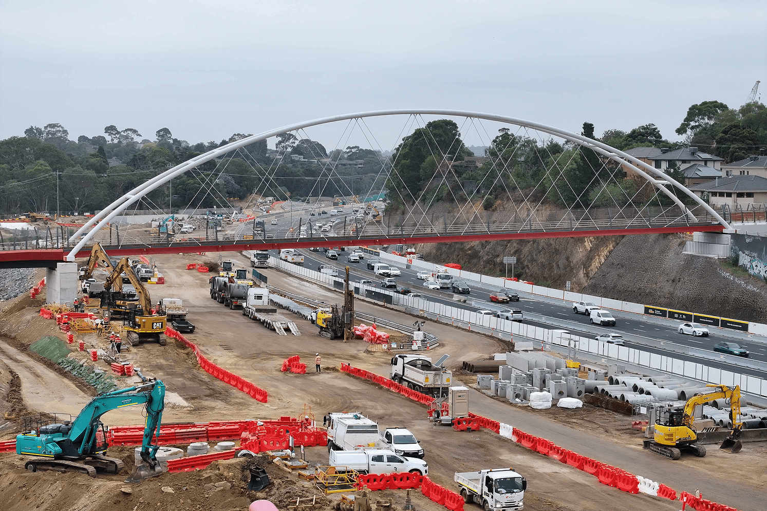 A construction site featuring a bridge under construction with several workers actively engaged in the building process.
