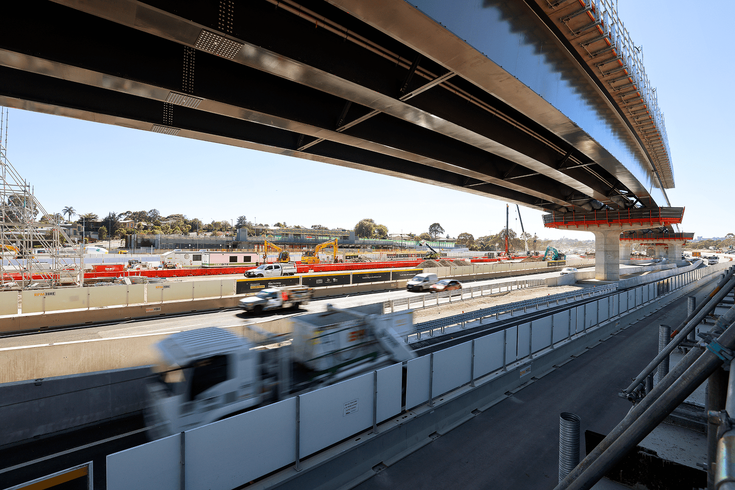 A bridge spans over a road, connecting two sides and allowing vehicles to pass underneath.