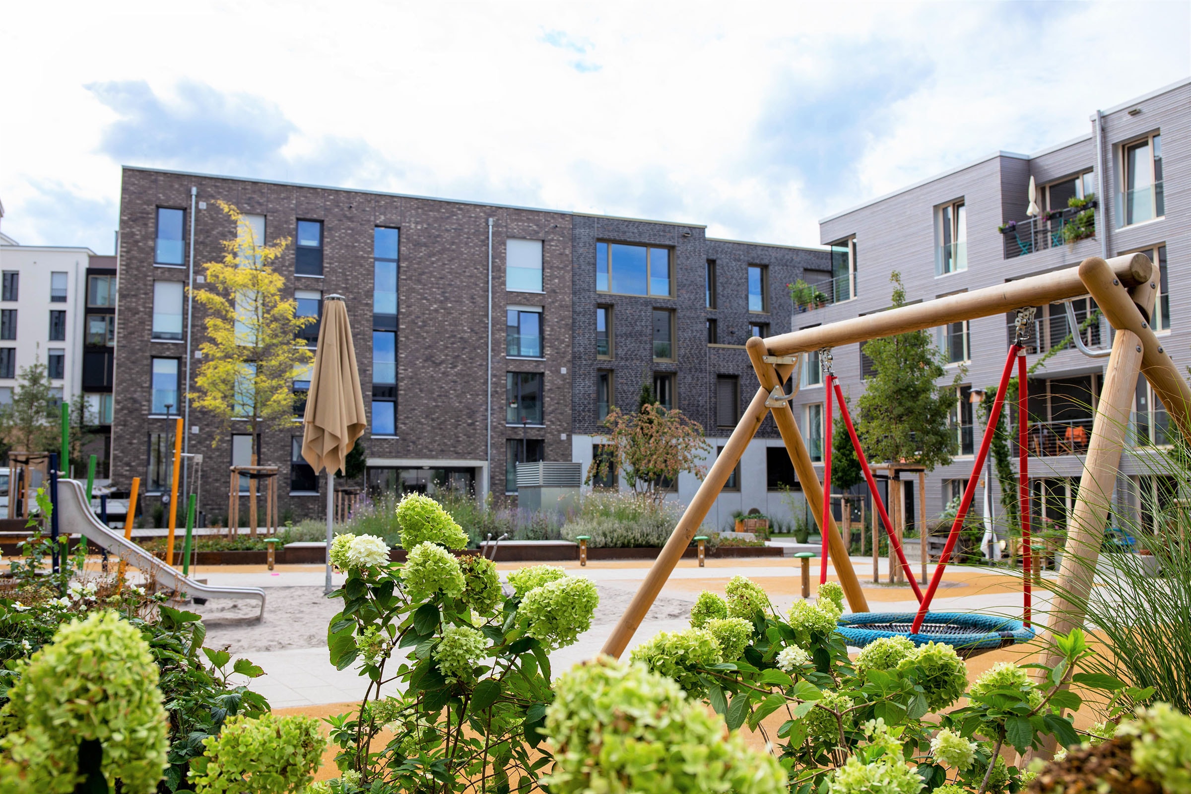 Wohnkomplex mit Spielplatz und Grünanlagen im Vordergrund