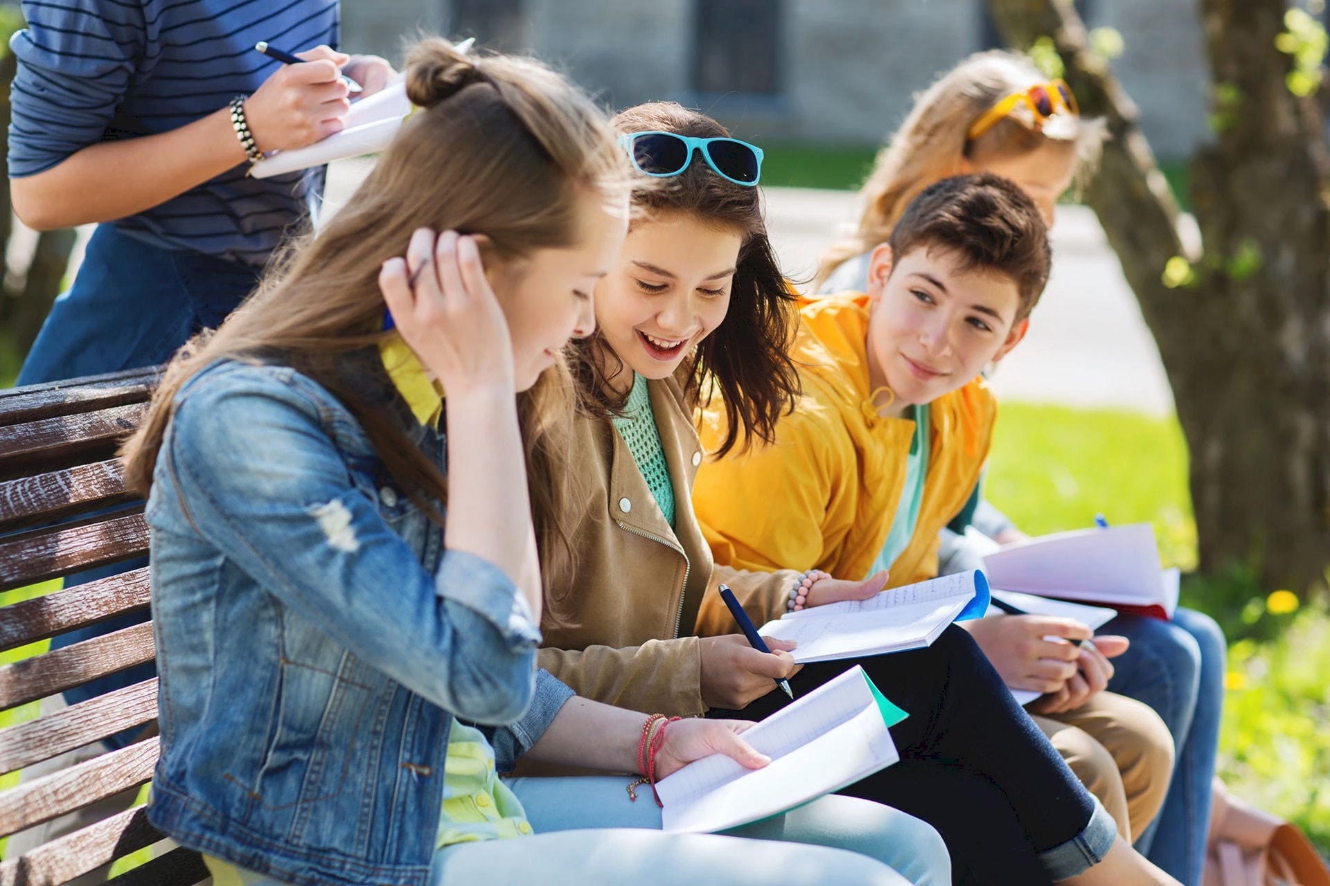 3 Schüler*innen besprechen Schulaufgaben auf dem Pausenhof