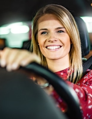 Blije vrouw achter het stuur van haar auto omdat ze niet meer in de file staat. Arcadis en verbreden A27 Hooipolder