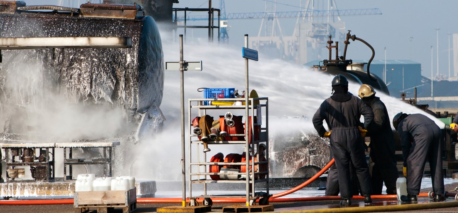 Brandweerlieden bezig met  het blussen van een tank met blusschuim