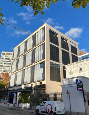 A building with a white van parked in front, showcasing a clear view of the structure and vehicle.
