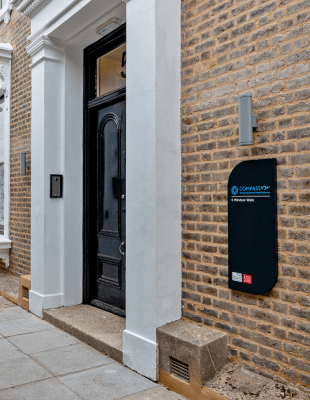 A brick building with a door and a sign on it.