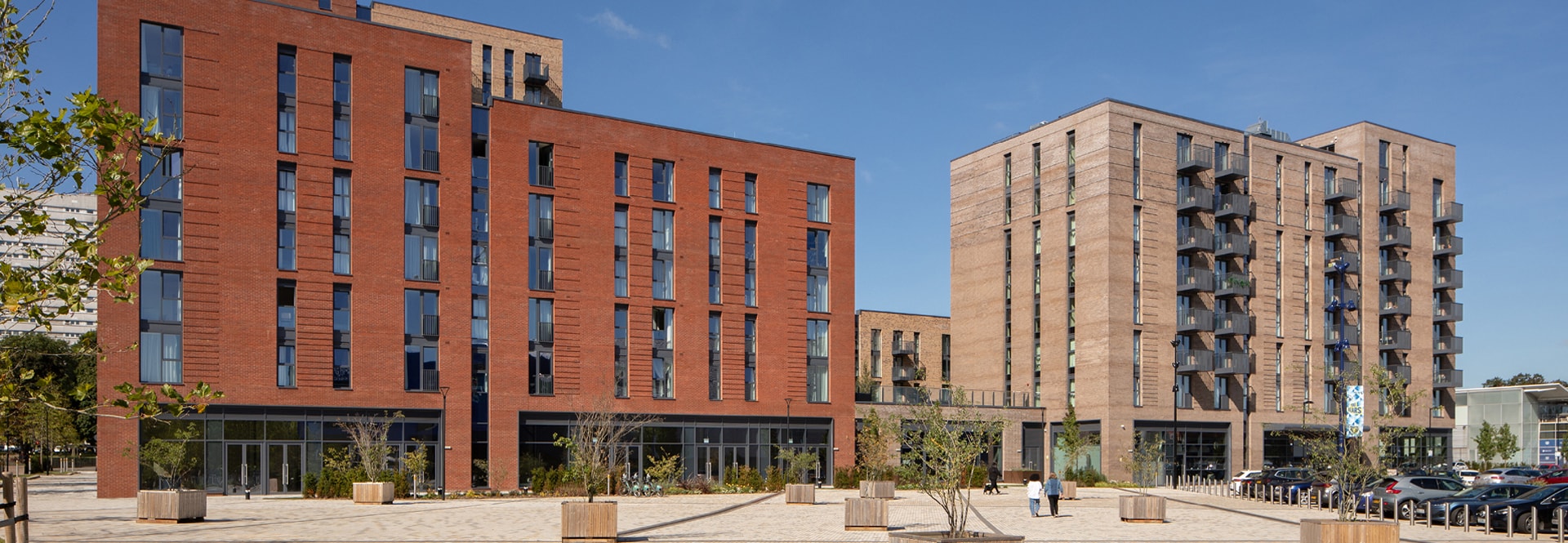 Two brick buildings featuring numerous windows and balconies, showcasing a blend of architectural design and urban living.